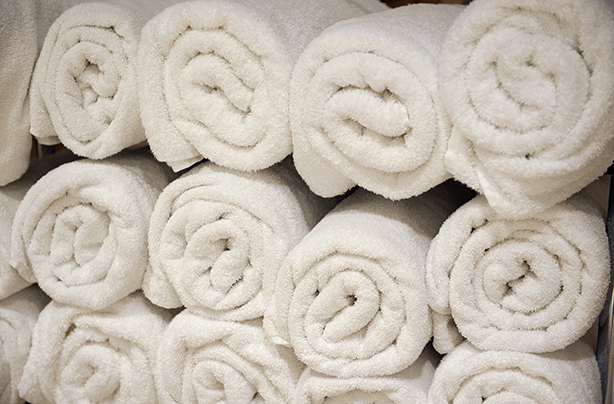 Fresh white towels rolled up and stacked on top of another