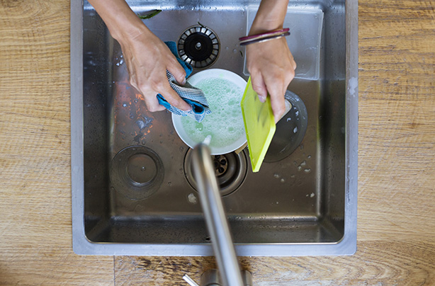 Woman washing dishes in a domestic kitchen