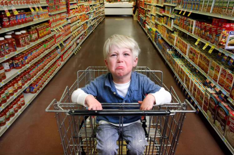 Boy crying in grocery cart.