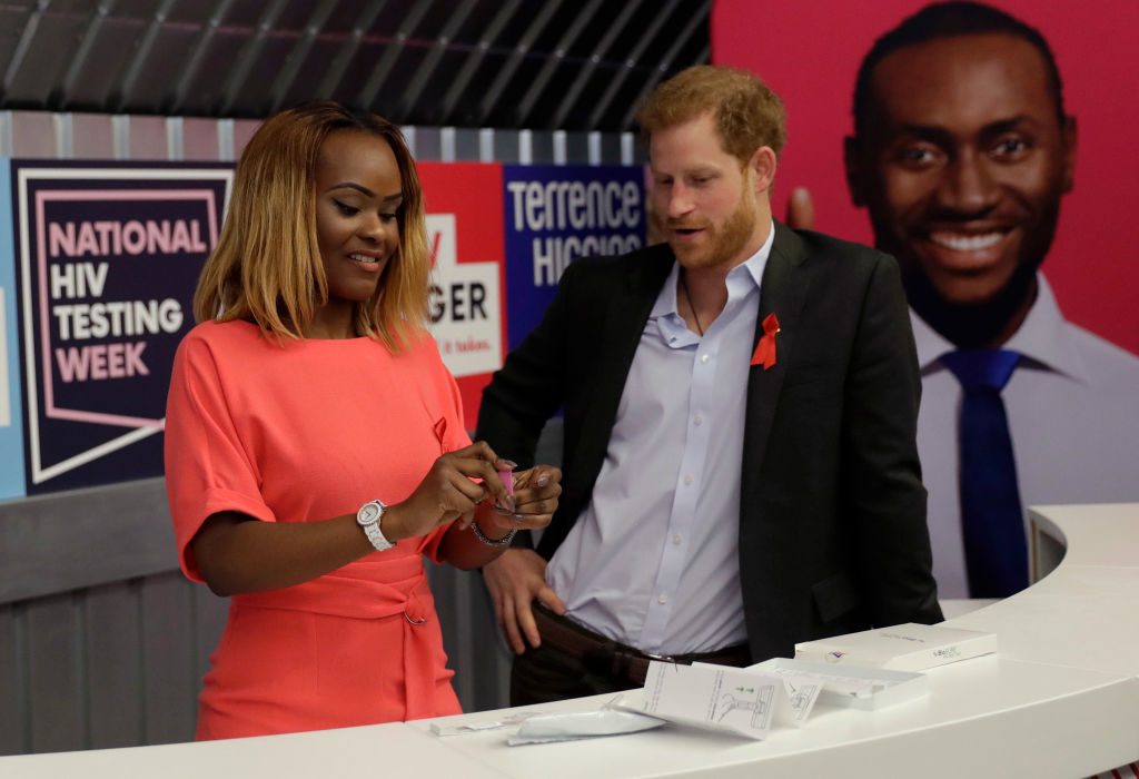 LONDON, ENGLAND - NOVEMBER 15:  Yvette Twagiramariya, one of the faces of the "It Starts With Me" campaign performs a pin prick to draw a blood sample, as she demonstrates a HIV self-test kit to Prince Harry during his visit to the opening of the Terrence Higgins Trust charity's HIV self-test pop-up shop in Hackney to launch National HIV Testing Week on November 15, 2017 in London, England. The charity aims to end the transmission of HIV in the UK and empower and support people living with HIV to lead healthy lives. (Photo by Matt Dunham - WPA Pool/Getty Images)